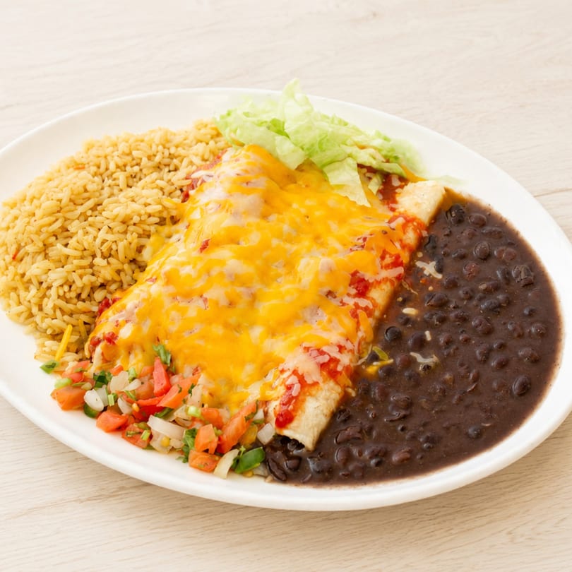 A plate of cheesy enchiladas with rice, black beans, pico de gallo, and shredded lettuce.